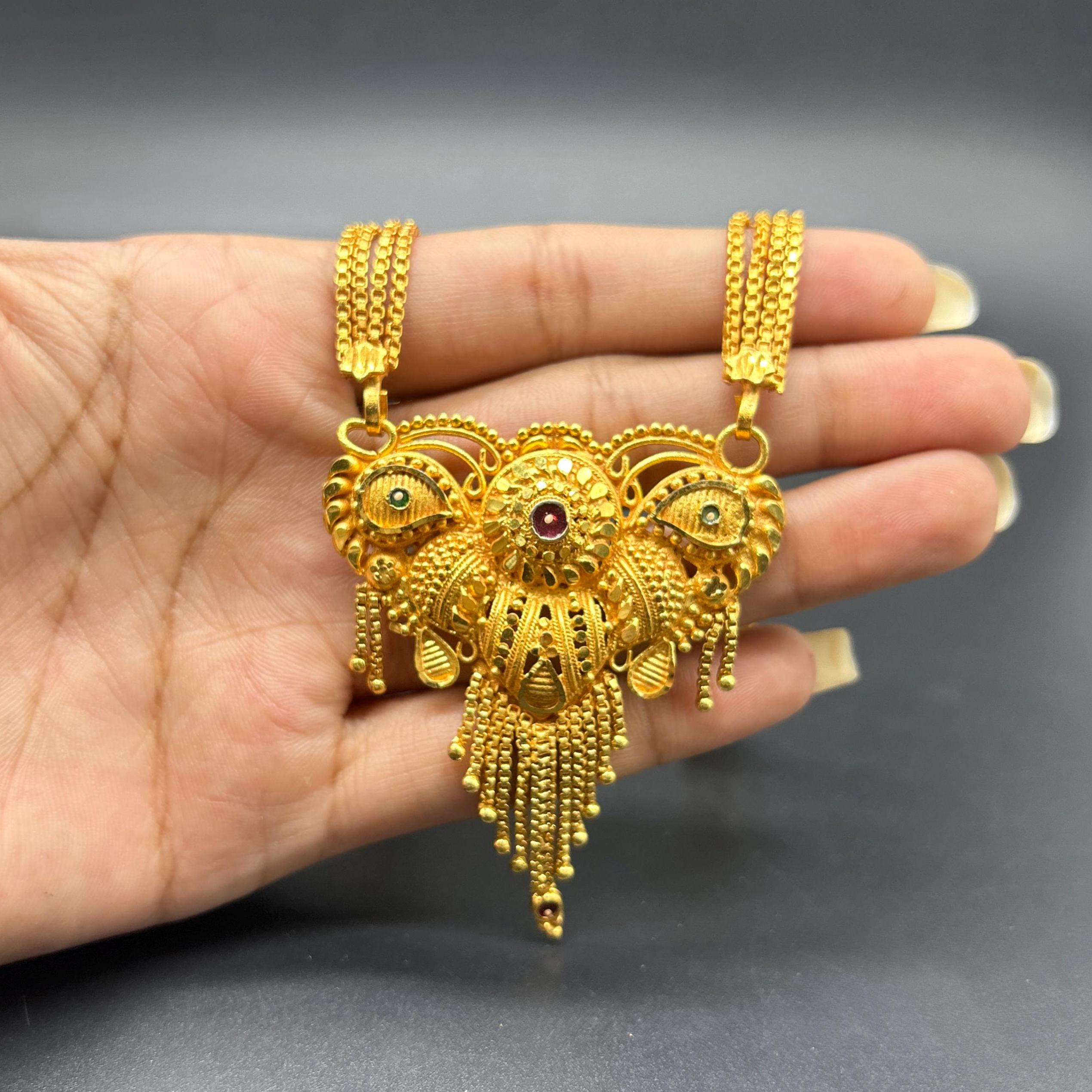 Gold-plated black beaded long mangalsutra, has a stylized centerpiece with textured details