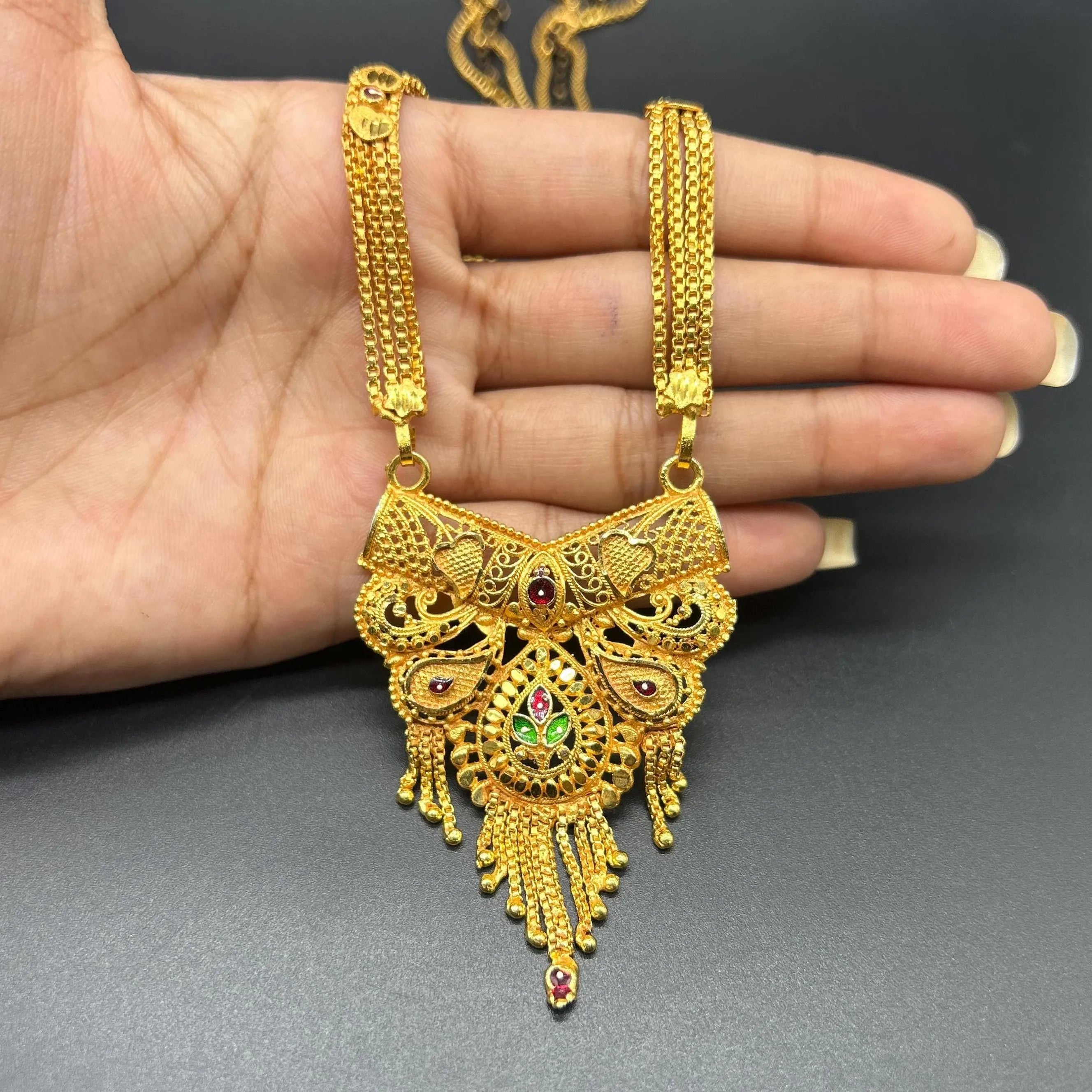 Gold-plated black beaded long mangalsutra, has a stylized centerpiece with textured details