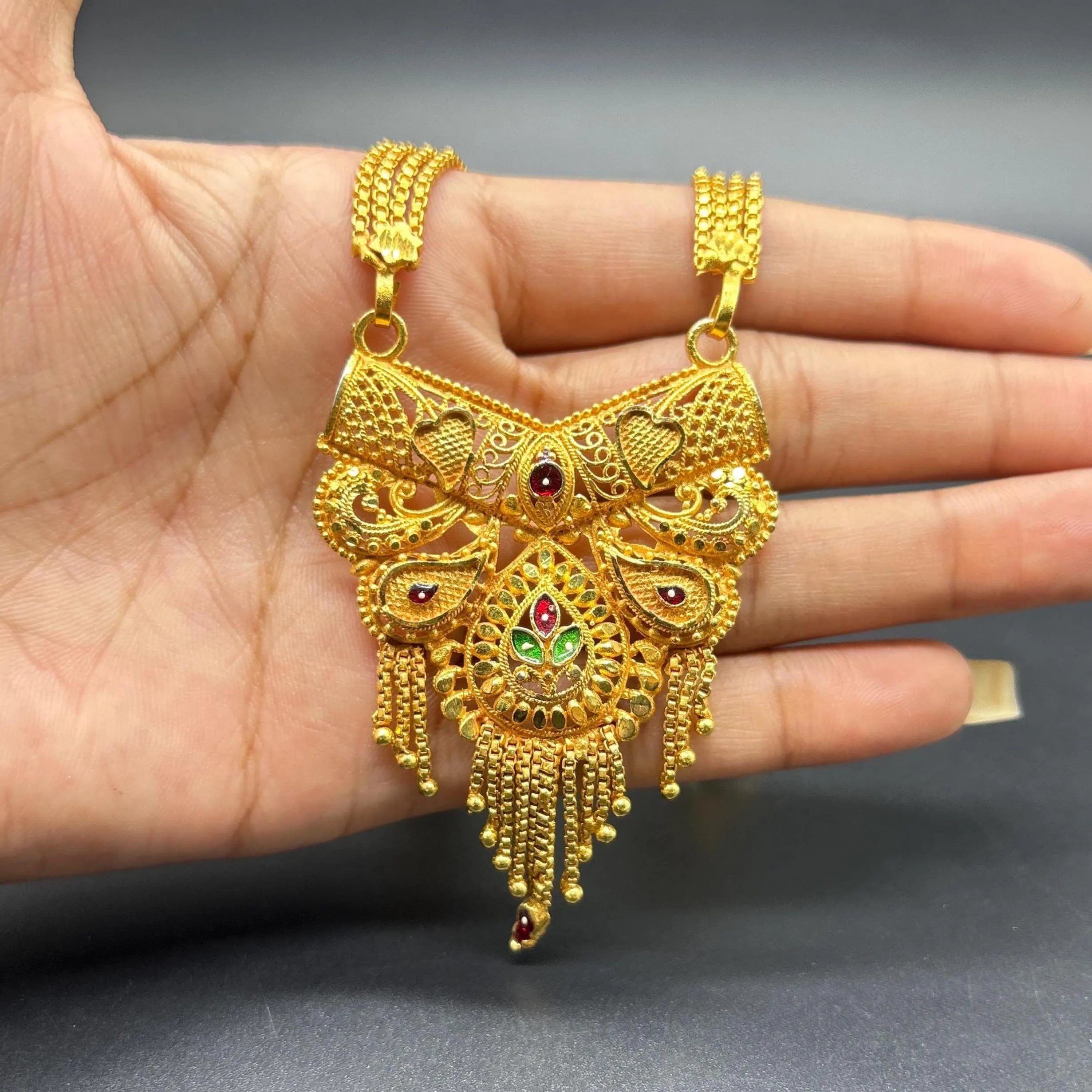 Gold-plated black beaded long mangalsutra, has a stylized centerpiece with textured details