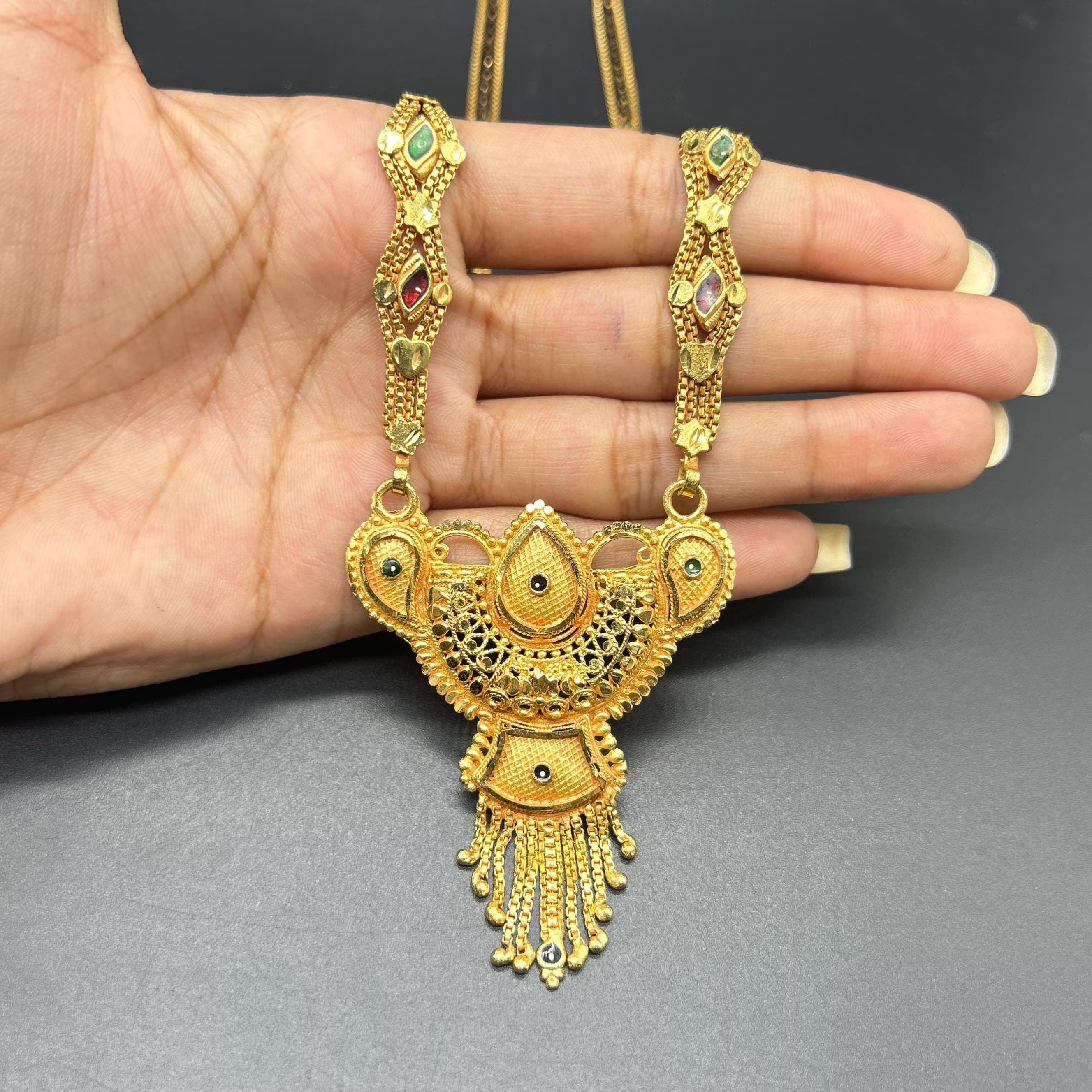 Gold-plated black beaded long mangalsutra, has a stylized centerpiece with textured details